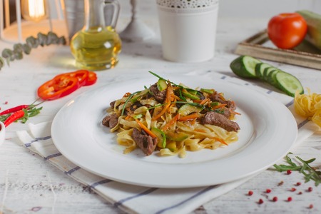 Spaghetti with Vegetables, Ham, Black Olives, Rucola and Pesto Sauceの写真素材