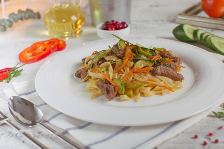 Spaghetti with Vegetables, Ham, Black Olives, Rucola and Pesto Sauceの写真素材