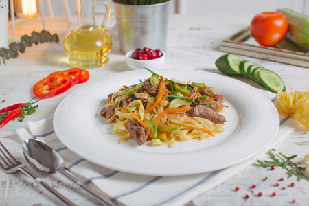 Spaghetti with Vegetables, Ham, Black Olives, Rucola and Pesto Sauceの写真素材