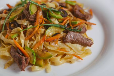 Spaghetti with Vegetables, Ham, Black Olives, Rucola and Pesto Sauceの写真素材