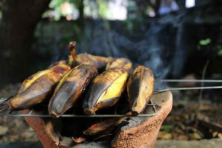 grilled banana with peel from charcoal on terracotta potの写真素材