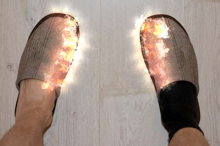 Legs in a brown sleepers and a black sock in the fireの写真素材