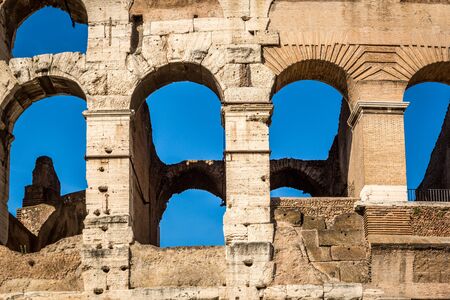 Detail of exterior arched openings / windows at the colosseum in Rome Italy, blue sky background.の写真素材