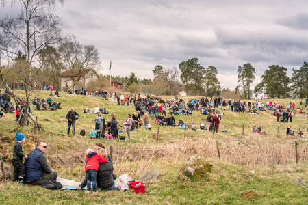 People having picnic on grass hill. Vallentuna, Sweden - May 06, 2017: Many people sitting and laying on grass hill and field having picnic. Landscape view of families children and adults outdoors.のeditorial素材