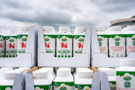 Milk cartons stacked outdoors.  Vallentuna, Sweden - May 06, 2017: Close up of many green milk cartons stacked in rows outdoors from Swedish milk manufacturer Arla, Labeled with their red cow logo.のeditorial素材