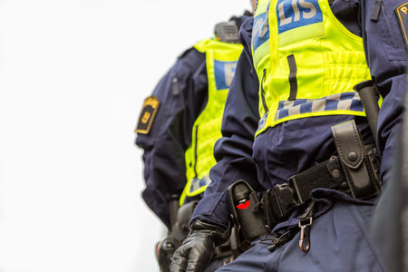 Two police officers, close up image from under of upper body with vest and equipment.