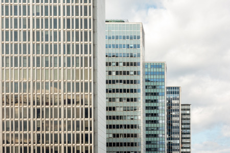Many old tall office buildings in a row with cloudy sky. Horizontal view.の写真素材