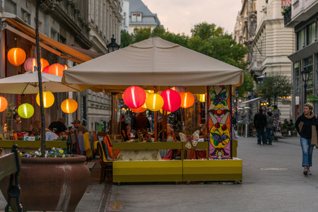 Budapest, Hungary - September 25, 2017: Street view of people in outdoor restaurant with colored rice lamps eating dinner. Pedestrian street Vaci utca in Budapest Hungary with incidental people walking by.のeditorial素材