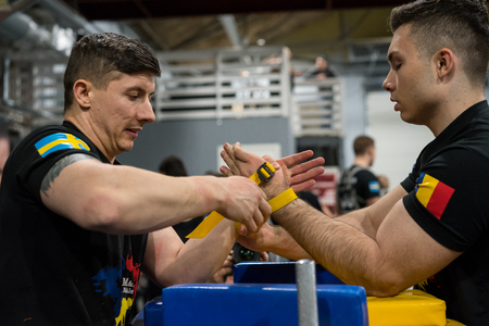 STOCKHOLM, SWEDEN - JANUARY 13, 2018: Profile view of a Swedish and Romanian male arm wrestler in a match at the event Arm Battle of Sweden outside of Stockholm January 13, 2018.のeditorial素材