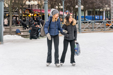 STOCKHOLM, SWEDEN - FEBRUARY 03, 2018: Front view of two girls skating at a public ice skating rink...