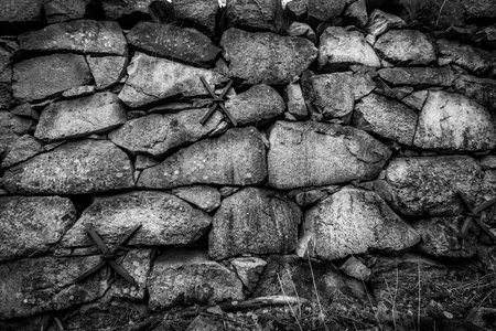 Closeup of black and white rock stone wall outdoors. Old vintage grunge texture structure.の写真素材