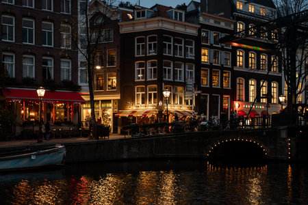 AMSTERDAM, NETHERLANDS - NOVEMBER 22,  2018: Night scene of water canal, buildings and neon lights and people on the street. Famous Redlight District city nightlife in Amsterdam Netherlands November 22, 2018.のeditorial素材