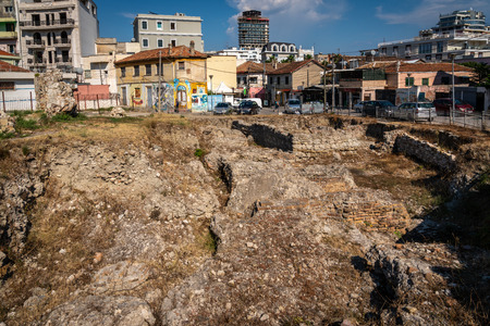 DURRES, ALBANIA - AUGUST 7, 2018: City view of a excavation site of a Roman ruin seen from above with residential buildings in the background in Durres Albania August 7, 2018.のeditorial素材