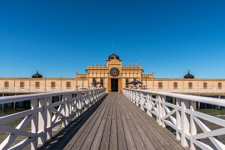 VARBERG, SWEDEN - JULY 16, 2019: Summer perspective view of the famous old historic wooden bathhouse Varbergs Kallbadhus. A cold water public bath located in the ocean with a bridge ashore with incidental people in Varberg Sweden July 16, 2019.のeditorial素材