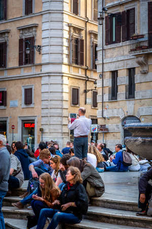 ROME, ITALY - APRIL 22, 2015: Closeup of people sitting on stone steps outdoor next to a fountain at the Pantheon building in Rome Italy April 22, 2015.のeditorial素材