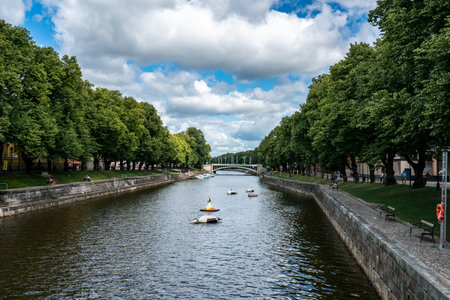 TURKU, FINLAND - JULY 14, 2016: Beautiful summer view of the canal with surrounding green trees and...