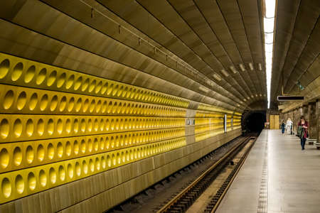 PRAGUE, CZECH REPUBLIC - SEPTEMBER 28, 2014: Perspective view of a beautiful decorated golden wall at an underground subway station with incidental people in Prague Czech Republic September 28, 2014.のeditorial素材