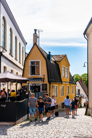 VISBY, SWEDEN - JULY 27, 2020: Summer city view of people at the famous landmark building cafe...