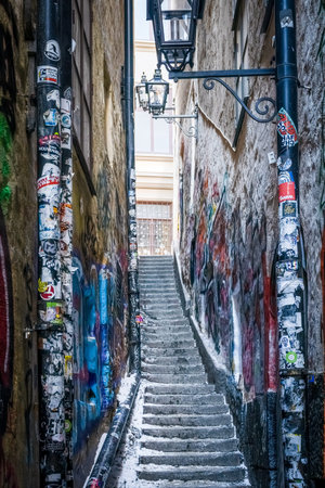 STOCKHOLM, SWEDEN - FEBRUARY 13, 2021: Perspective view of narrow street with snowy steps and...