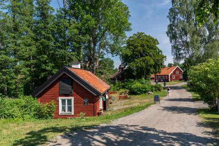 VIRA BRUK, SWEDEN - JULY 5, 2021: Summer view of old red traditional Swedish wooden buildings. Historic open-air museum Vira Bruk with incidental people in Vira Bruk Sweden July 5, 2021.のeditorial素材