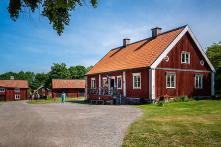 VIRA BRUK, SWEDEN - JULY 5, 2021: Summer view of old red traditional Swedish wooden buildings. Historic open-air museum Vira Bruk with incidental people in Vira Bruk Sweden July 5, 2021.のeditorial素材