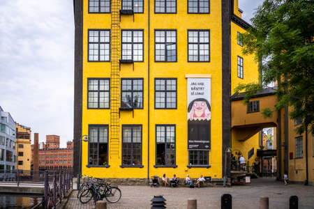 NORRKOPING, SWEDEN - JULY 27, 2021: Closeup front facade view of a famous old yellow industrial building. Museum Arbetets Hus with incidental people in Norrkoping Sweden July 27, 2021.のeditorial素材