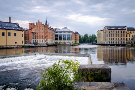 NORRKOPING, SWEDEN - JULY 27, 2021: Beautiful cityscape with old industrial buildings and water reservoir and incidental people in Norrkoping July 27, 2021.のeditorial素材