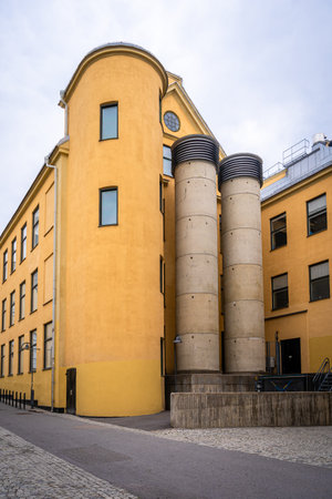 Old yellow city industrial stone building with chimneys in Norrkoping Sweden.のeditorial素材