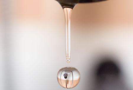 drop of water from faucet in bathroom with reflectionの写真素材
