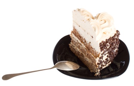 close-up piece of cake and spoon on black plate, isolatedの写真素材