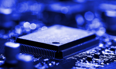 close-up chip on circuit board with selective focus, blue toned