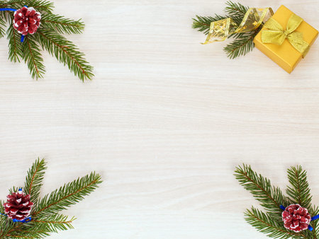 christmas background with fir tree branches, cones and gift box on wooden backgroundの写真素材
