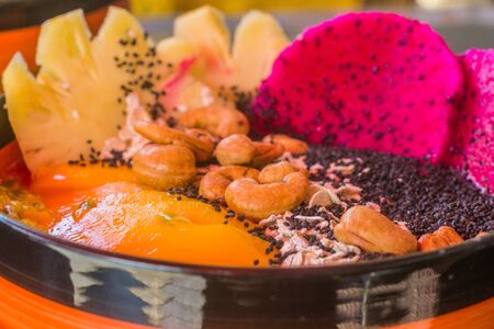 A tropical fruit salad with mixed fruits and nutsの写真素材