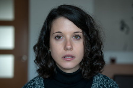 Young non-professional model photographed inside a house with natural poses and melancholy attitude.