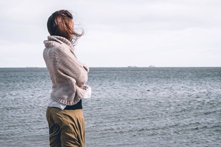 Young girl, wearing casual clothes, photographed on the beach in winter.の写真素材