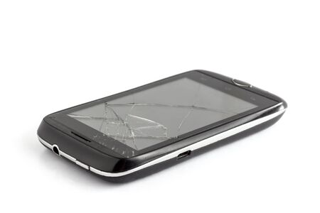 a black broken smartphone with cracked screen isolated on white backgroundの写真素材