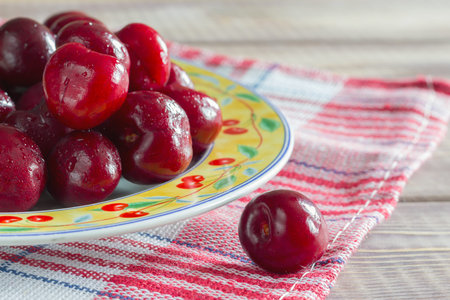 cherries on the table in plate red napkin
