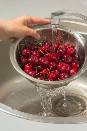 hand washing cherries kitchen sinkの写真素材