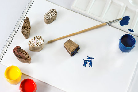 indian stamp blocks composition with paint, brush and paper