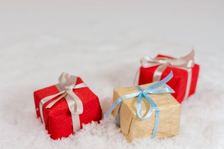 three small Christmas presents on snow, shallow depth of sceeneの写真素材