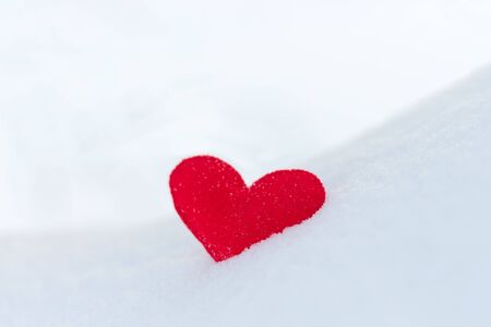 red felt heart figure on snow, winter dayの写真素材