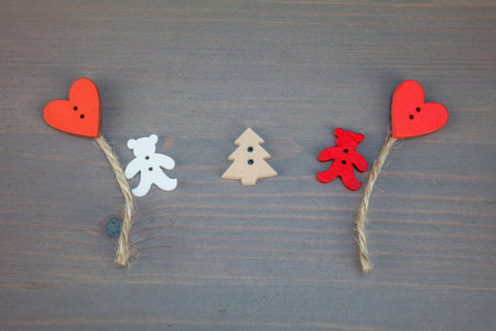 Two bears with balloons-hearts and tree on grey wooden background. Button bears love. Button love....