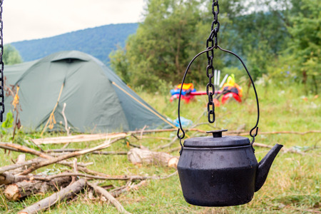 Old traditional black teapot on campfires during camping trip on a catamaran on a Dniester river.の写真素材