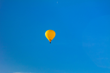 Colorful hot air balloon in flight over blue sky.の写真素材