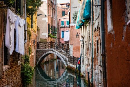 Traditional canal street with gondolas and boats in Venice, Italy.の写真素材