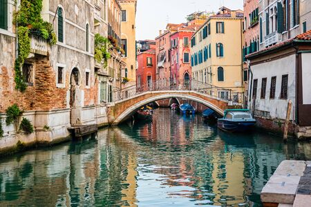 Traditional canal street with gondolas and boats in Venice, Italy.の写真素材