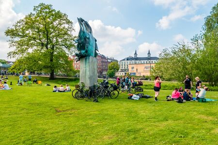 Odense, Denmark - May, 2019: Street life in Odense. People spend time relaxing in the park.の写真素材