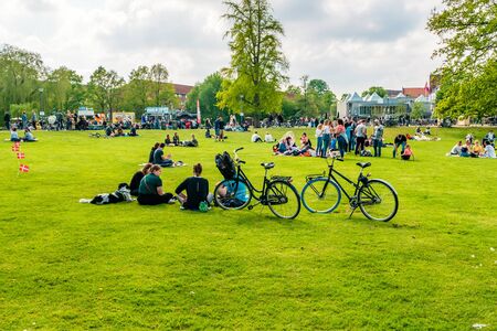 Odense, Denmark - May, 2019: Street life in Odense. People spend time relaxing in the park.の写真素材