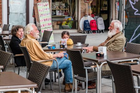 Venice, Italy - October, 2019: Street life in Venice. People relaxing in a street cafe.のeditorial素材
