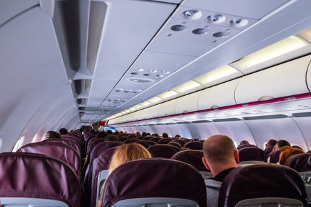 Interior of airplane with passengers on seats.